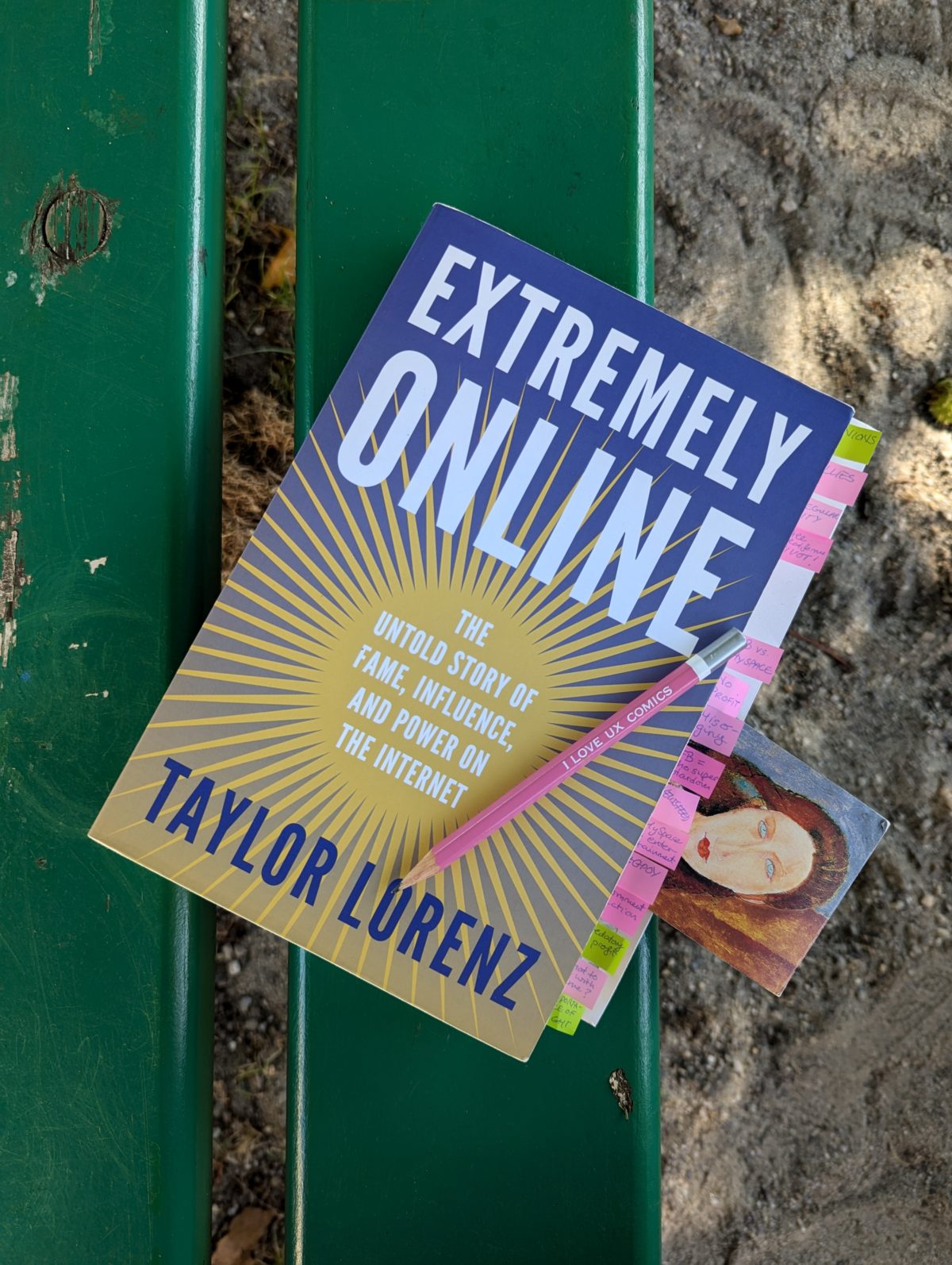 Exemplaire de «Extremely Online : The Untold Story of Fame, Influence, and Power on the Internet» de Taylor Lorenz posé sur un banc vert avec des post-its qui dépassent